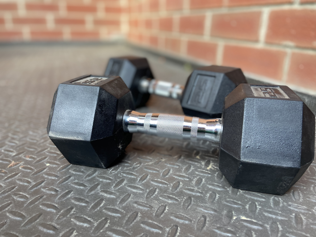 dumbells on gym floor exposed brick background